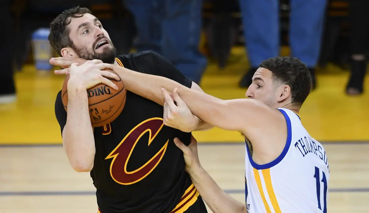 Pemain Golden State Warriors, Klay Thompson berebut bola dengan pemain Cleveland Cavaliers, Kevin Love saat pertadingan gim kelima Final NBA 2017 di Oakland, California (12/6). (Thearon W. Henderson/Getty Images/AFP)