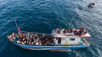 Pengungsi etnis Rohingya berada di atas kapal milik nelayan Indonesia di pesisir Pantai Seunuddon, Aceh Utara (24/6/2020).  Para pengungsi Rohingya diselamatkan nelayan Aceh setelah kapal yang ditumpangi puluhan pengungsi itu rusak. (AP Photo/Zik Maulana)
