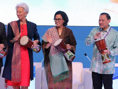 Menko Kemaritiman Luhut Pandjaitan, Direktur Pelaksana IMF Christine Lagarde, Menkeu Sri Mulyani bersama Gubernur BI Agus Martowardojo memukul tifa saat pembukaan High - Level International Conference di Jakarta, Selasa (27/2). (Liputan6.com/JohanTallo)