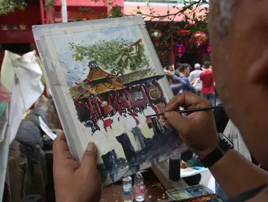 Anggota komunitas pelukis cat air Indonesia melukis suasana perayaan Imlek di Vihara Dharma Bhakti, Petak Sembilan, Jakarta Barat, Sabtu (25/1/2020). Kegiatan melukis tersebut untuk memeriahkan perayaaan Tahun Baru Imlek 2571. (Liputan6.com/Angga Yuniar)