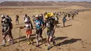 Para peserta bersaing dalam kejuaraan Marathon des Sables ke-32 tahap ketiga di Gurun Sahara, selatan Maroko, Selasa (11/4). Para peserta diwajibkan membawa tas berisikan makanan, perlengkapan tidur dan material lainnya. (JEAN-PHILIPPE KSIAZEK/AFP)