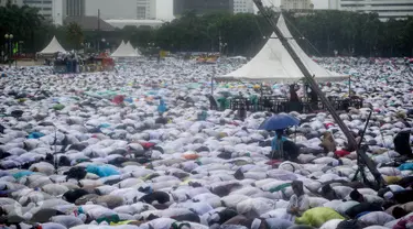 Massa aksi damai 2 Desember bersujud saat menunaikan ibadah salat Jumat di Monas, Jakarta, Jumat (2/12). Meski hujan mengguyur, massa tetap bertahan di saf masing-masing dan melangsungkan salat Jumat bersama-sama. (Liputan6.com/Faizal Fanani)