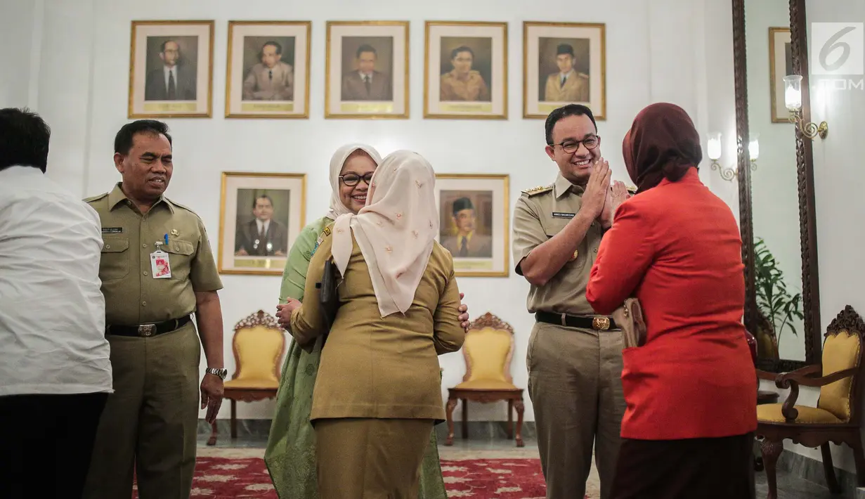 Gubernur DKI Jakarta Anies Baswedan didampingi istrinya Fery Farhati Ganis bersalaman dengan pegawai Pemprov dan warga Jakarta saat menggelar halal bihalal di Balaikota, Jakarta, Senin (10/6/2019). (Liputan6.com/Faizal Fanani)