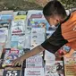 Seorang anak memilih buku saat kehadiran Perpustakaan Keliling di kawasan Kampung Melayu, Jakarta, Minggu (16/8/2020). Kegiatan sosial ini menghadirkan latihan tari, donasi pakaian layak, makanan, serta masker. (merdeka.com/Iqbal S. Nugroho)