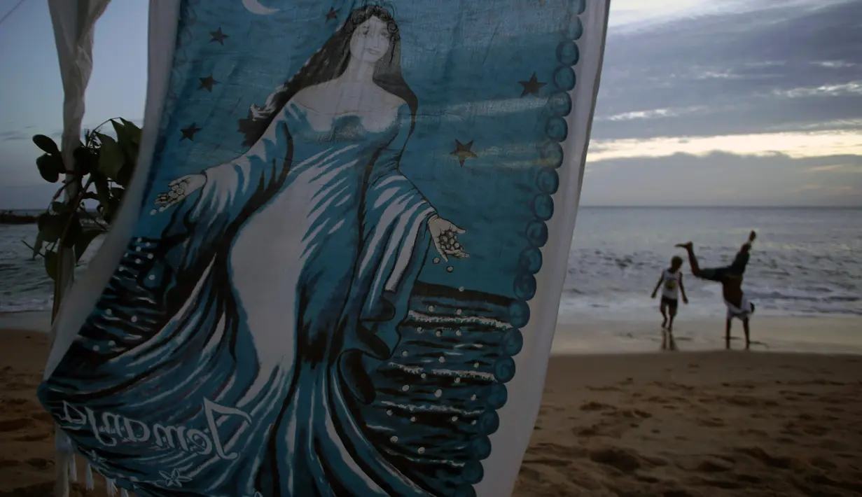 Sebuah kain lukisan dari Dewi Laut Yemanja yang tergantung saat perayaan Dewi Laut Yemanja di Salvador, Brasil (2/2). Perayaan ini bentuk syukur warga pesisir Brasil kepada Dewi Laut. (AP Photo / Eraldo Peres)