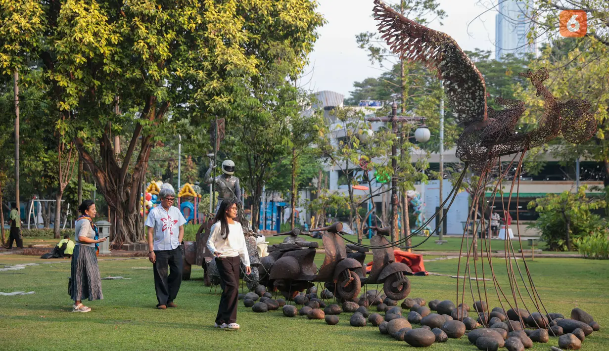 Pengunjung mengamati karya dalam pameran seni rupa kontemporer luar ruang Jakarta Provoke! di Taman Menteng, Jakarta Pusat, Jumat (17/7/2026). Pameran gratis yang berlangsung hingga 26 Juli 2026 ini menghadirkan 25 karya dari 25 seniman dan kolektif tentang dinamika kehidupan Jakarta. (KLY/Budy Santoso)
