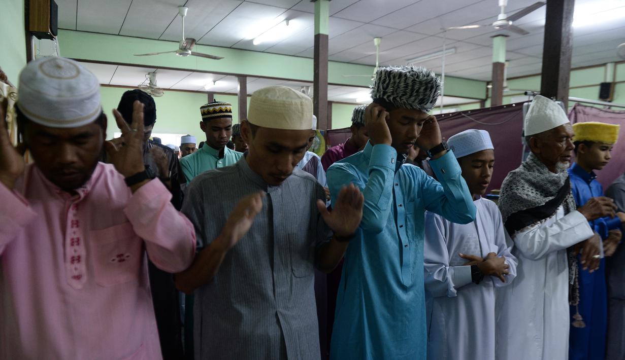 Umat muslim Thailand melaksanakan salat Idul Fitri 1439 H di atap sebuah masjid yang belum selesai di Manila, Filipina (15/6). Umat muslim di seluruh dunia tengah merayakan Hari Raya Idul Fitri 1439 H. (AFP Photo/Madaree Tohlala)