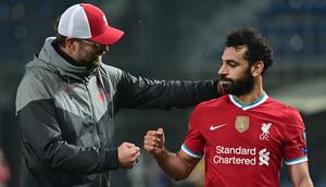Pelatih Liverpool, Jurgen Klopp, memberikan selamat kepada Mohamed Salah usai timnya meraih kemenangan atas Atalanta pada laga lanjutan Liga Champions 2020/2021 di Gewiss Stadium, Rabu (4/11/2020) dini hari WIB. Liverpool menang 5-0 atas Atalanta. (AFP/Miguel Medina)