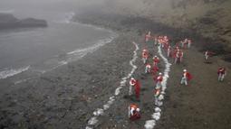 Pekerja melanjutkan kampanye pembersihan minyak di Pantai Cavero, Distrik Ventanilla Callao, Peru, 15 Februari 2022. Sebulan berlalu, pekerja melanjutkan pembersihan di pantai setelah terkontaminasi tumpahan minyak Repsol. (AP Photo/Martin Mejia)