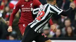 Gelandang Liverpool, Jordan Henderson berebut bola dengan bek Newcastle United, DeAndre Yedlin pada pertandingan Liga Inggris di Stadion Anfield, Rabu (26/12). Liverpool bertahan di puncak klasemen setelah menghajar Newcastle United 4-0. (Paul ELLIS/AFP)