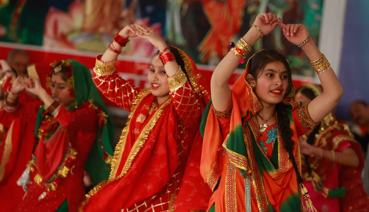 Gadis-gadis India mengenakan pakaian tradisional menari saat mereka merayakan festival Lohri di Jammu, India (13/1). Lohri adalah sebuah perayaan Punjabi populer yang merayakan titik balik musim dingin. (AP Photo / Channi Anand)