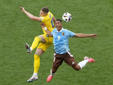 Gelandang Belgia Youri Tielemans melakukan sundulan dengan penyerang Ukraina Artem Dovbyk pada laga terakhir grup E Euro 2024 di Stuttgart Arena, Rabu (26/6/2024) malam WIB. (AP Photo/Antonio Calanni)