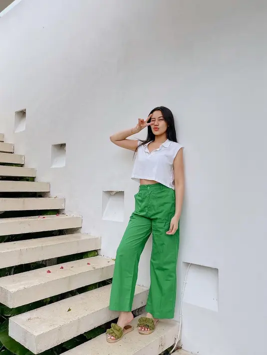 Sleeveless top warna putih dan high waisted pants warna hijau, nyaman untuk hangout. [Instagram/aaliyah.massaid]