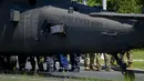 Prajurit berjalan dengan helikopter Black Hawk militer AS setelah mendarat darurat di boulevard yang sibuk, di Bucharest, Rumania, Kamis (15/7/2201). Pendaratan itu merusak dua mobil setelah merobohkan dua tiang lampu namun tidak ada korban yang dilaporkan. (AP Photo/Andreea Alexandru)