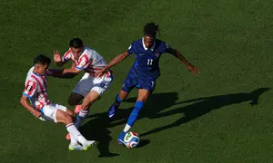 Pemain Prancis Michael Olise  berebut bola dengan pemain Paraguay Diego Gomez dan Andres Cubas  saat pertandingan sepak bola babak 16 besar Piala Dunia di Philadelphia, Sabtu (04/07/2026). (AP Photo/Matt Rourke)