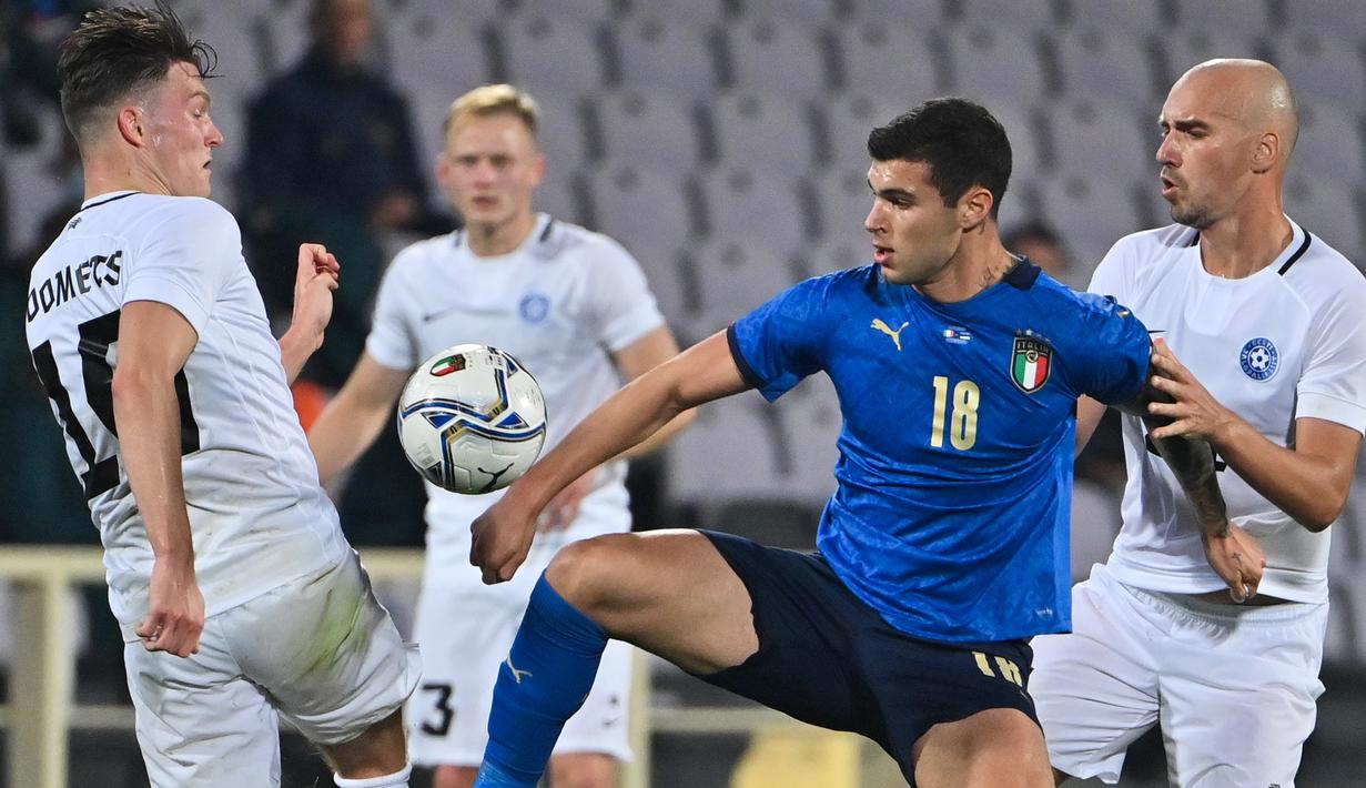 Penyerang Italia, Pietro Pellegri, berebut bola dengan gelandang Estonia, Markus Soomets, pada laga uji coba di Stadion Artemino Franchi, Kamis (12/11/2020) dini hari WIB. Italia menang 4-0 atas Estonia. (AFP/Alberto Pizzoli)