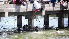 Warga berusaha menolong seorang anak kecil yang terjatuh ke laut di dermaga Muara Angke, Jakarta, Kamis (24/3). Akibat kelalaian ibunya seorang anak tercebur ke laut dan langsung di selamatkan warga dan prajurit TNI AL. (Liputan6.com/Faizal Fanani)