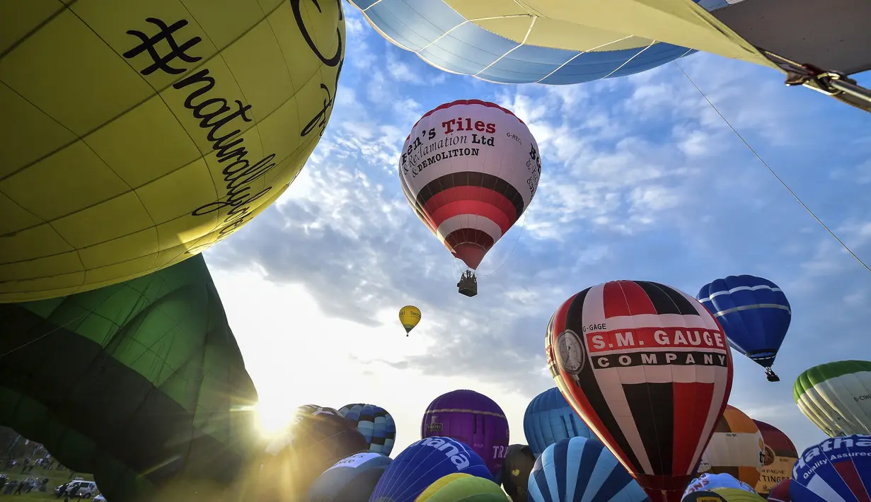 Sejumlah balon bersiap lepas landas massal dalam festival tahunan balon udara panas Bristol di Bristol, Inggris (8/8/2019). Ratusan balon terbang menghiasi langit Inggris dalam festival tahunan balon udara panas Bristol selama akhir pekan mendatang saat cuaca cerah. (Ben Birchall/PA via AP)