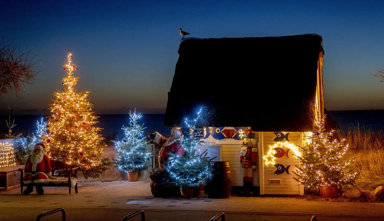Pohon Natal dan Sinterklas menghiasi pintu masuk pantai di Haffkrug, Jerman utara, Senin (20/12/2021). (AP Photo/Michael Probst)