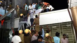 Petugas penyelamat menurunkan tubuh salah satu korban kebakaran besar yang melanda rumah sakit SUM Bhubaneshwar di Odisha, India Timur, Senin (17/10). Api diduga muncul karena hubungan arus pendek, namun dugaan itu masih diselidiki pihak berwenang. (AFP)