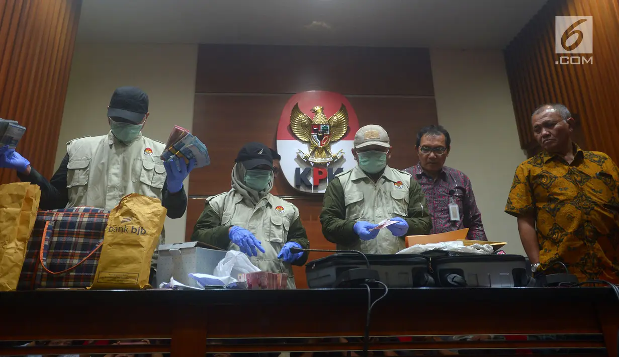 Penyidik KPK menunjukkan barang bukti OTT terhadap anggota Komisi XI Amin Santono, Jakarta, Sabtu (5/5). KPK menyita emas seberat 1,9 Kg, uang Rp 1,8445 miliar (termasuk yang 400 juta OTT), SGD 63.000 dan USD 12.500. (Merdeka.com/Imam Buhori)