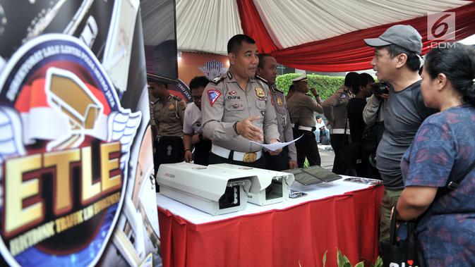 Polisi menyosialisasikan sistem Electronic Traffic Law Enforcement (ETLE) kepada warga di kawasan Bundaran HI, Jakarta, Minggu (25/11). Bukti tilang akan dikirimkan ke kediaman masing-masing pelanggar. (Merdeka.com/Iqbal Nugroho)