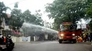 Petugas menerjunkan mobil pemadam kebakaran di luar kantor Kelurahan Arjuna, Kecamatan Cicendo, Bandung, Senin (27/2). Seorang terduga pelaku ledakan bom panci bersembunyi di kantor kelurahan, dan membakar gedung lantai dua. (Timor Matahari/AFP)