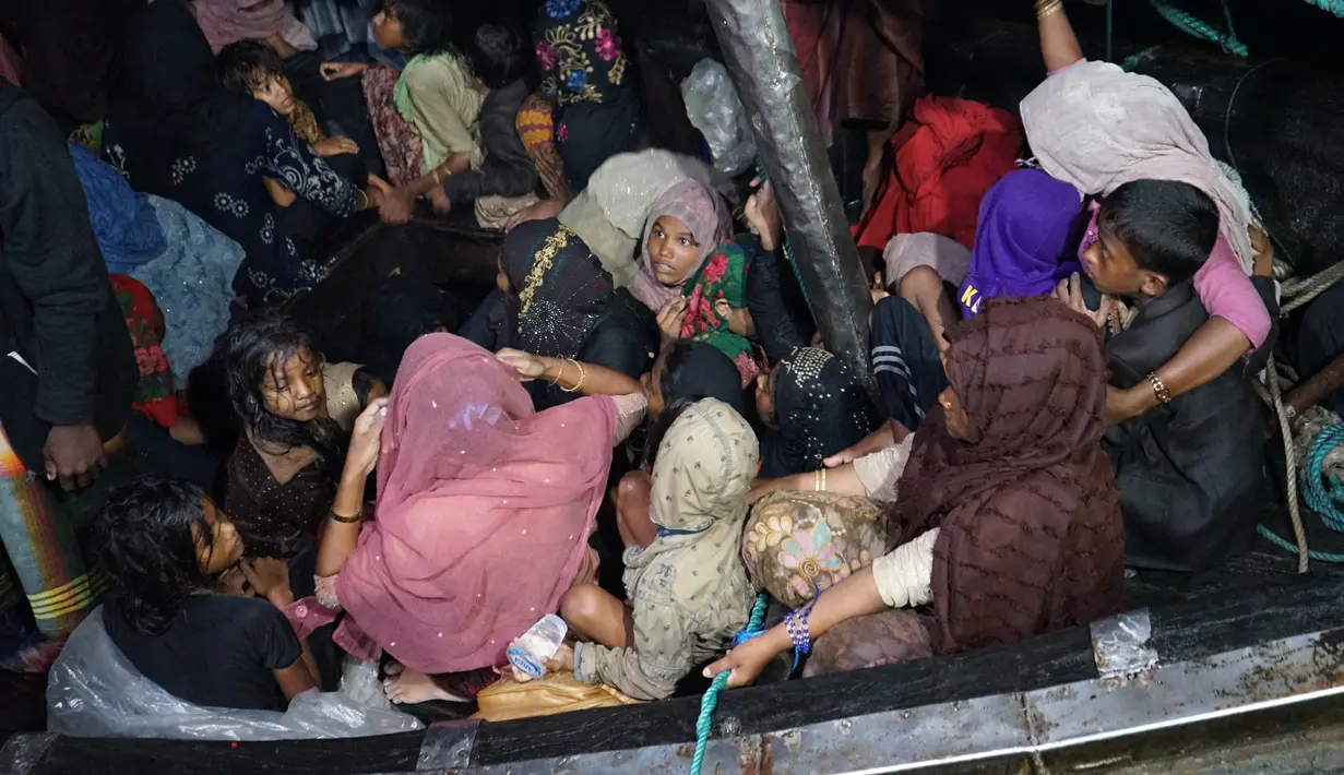 Pengungsi Rohingya duduk di perahu saat tiba di Pelabuhan Krueng Geukueh di Aceh Utara, Jumat pagi (31/12/2021). Pengungsi Rohingya tiba di Pelabuhan Asean, Kreueng Geukeuh, Kabupaten Aceh Utara, pada Kamis (30/12/2021) malam, setelah kapal motornya ditarik KRI Parang-647. (AP Photo/M. Yasir)