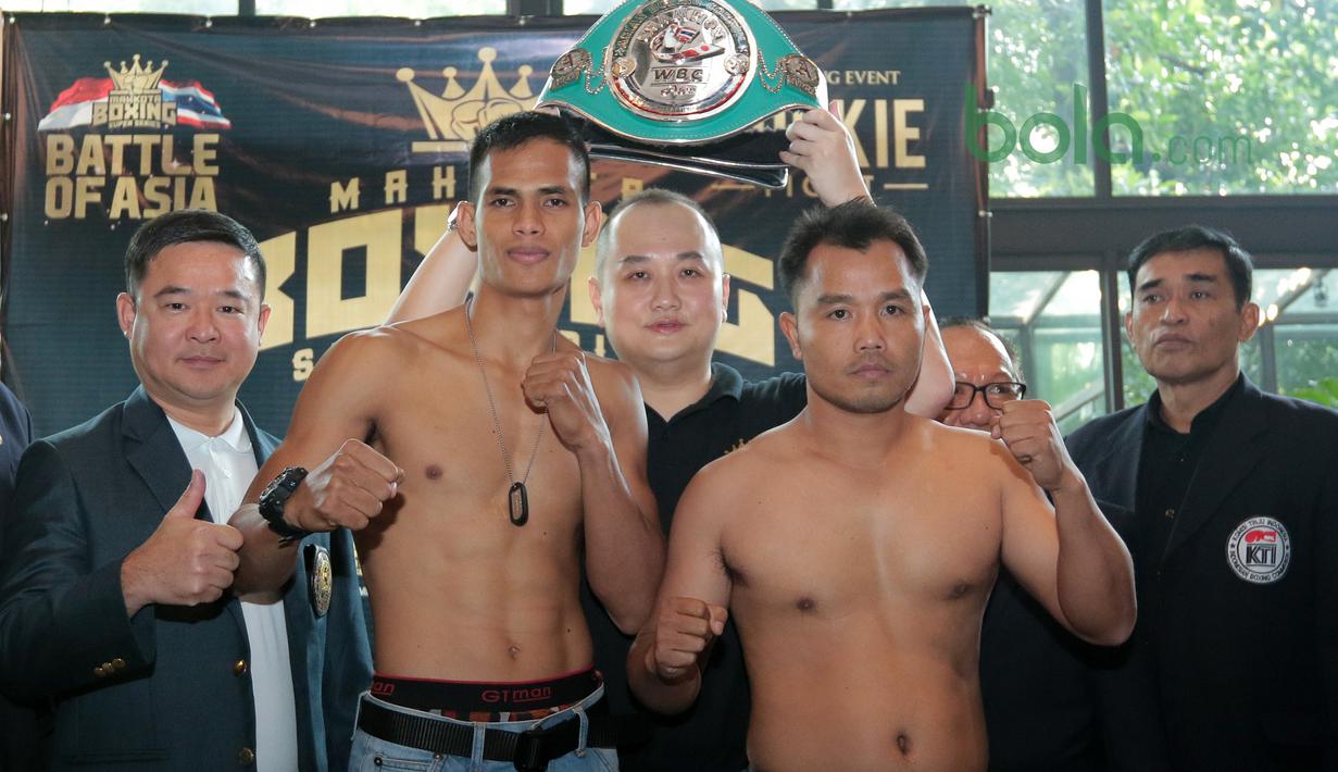 Petinju Indonesia, Ilham Leoisa (2kiri) dan petinju Thailand, Paiboon Lorkham (2kanan) saat melakukan timbang badan di Leon Restourant, Wijaya, Jakarta (09/3/2018). Ilham dan Paiboon turun pada kelas Super-Lightweight. (Bola.com/Nick Hanoatubun).