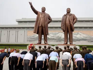 Tentara memberi hormat ketika yang lain membungkuk di hadapan patung pemimpin Korea Utara Kim Il Sung dan Kim Jong Il dalam peringatan berakhirnya Perang Dunia II dan pembebasan dari kolonial Jepang di Pyongyang, Korut, Rabu (15/8). (AP Photo/Ng Han Guan)