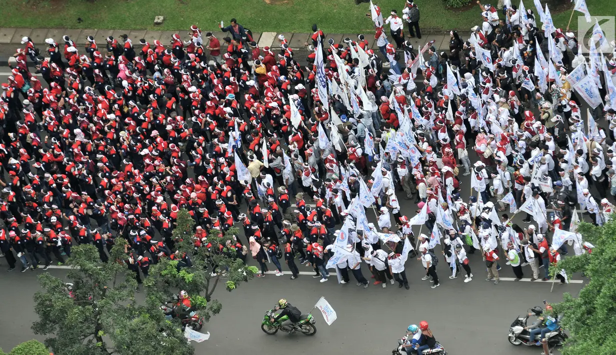 Peserta aksi dari sejumlah elemen buruh melakukan konvoi dalam peringatan Hari Buruh Sedunia di kawasan Jakarta, Rabu (1/5/2019). Buruh dari berbagai daerah di Jabodetabek serentak turun ke jalan menuju Istana Negara untuk menyuarakan 7 tuntutan. (merdeka.com/Iqbal S Nugroho)