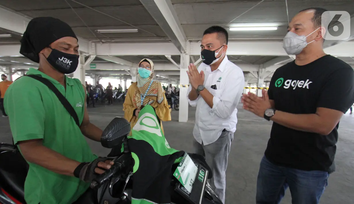 VP Public Policy & Goverment Relations Gojek Gautama Adi Kusuma (kedua kanan) dan Head of Strategy Regional PPGR Gojek T Mufizar Mahmud (kanan) menyapa Mitra Gojek di sentra vaksinasi Indonesia bangkit Rumah Sakit UI, Depok, Rabu (02/06/2021). (Liputan6.com/HO/Ading)
