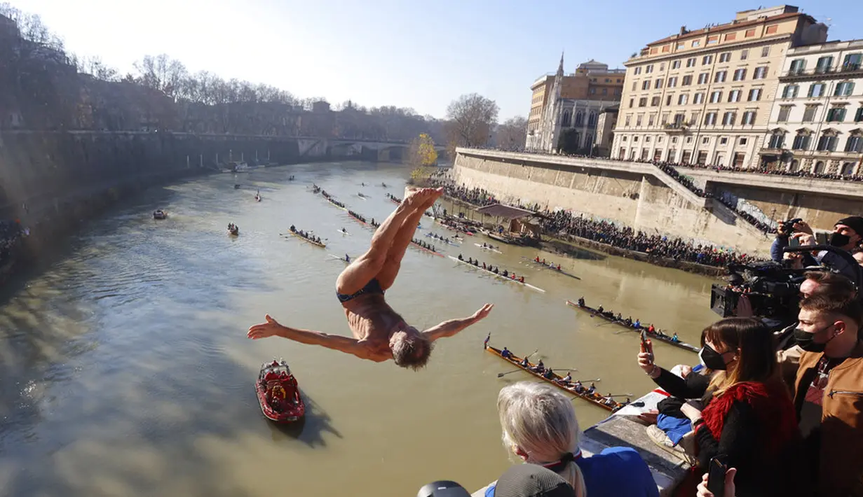 Marco Fois dari Italia melompat ke Sungai Tiber dari Jembatan Cavour setinggi 18 meter (59 kaki) untuk merayakan Tahun Baru di Roma, 1 Januari 2022. (AP Photo/Riccardo De Luca)