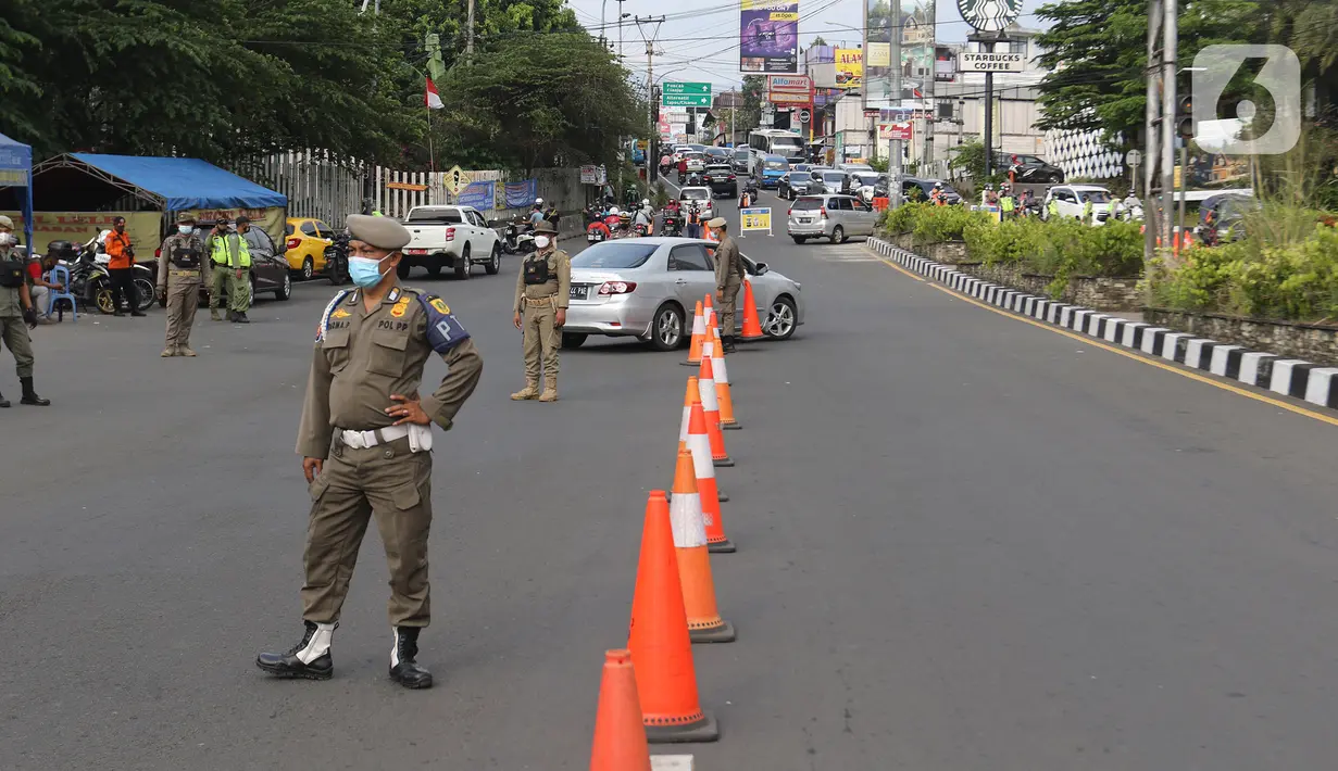 Petugas gabungan mengarahkan kendaraan saat penerapan ganjil genap di Jalan Raya Puncak, Gadog, Kabupaten Bogor, Jawa Barat, Jumat (3/9/2021). Jika uji coba tersebut efektif mengurai kepadatan akan dilanjutkan terus setiap akhir pekan. (Liputan6.com/Herman Zakharia)