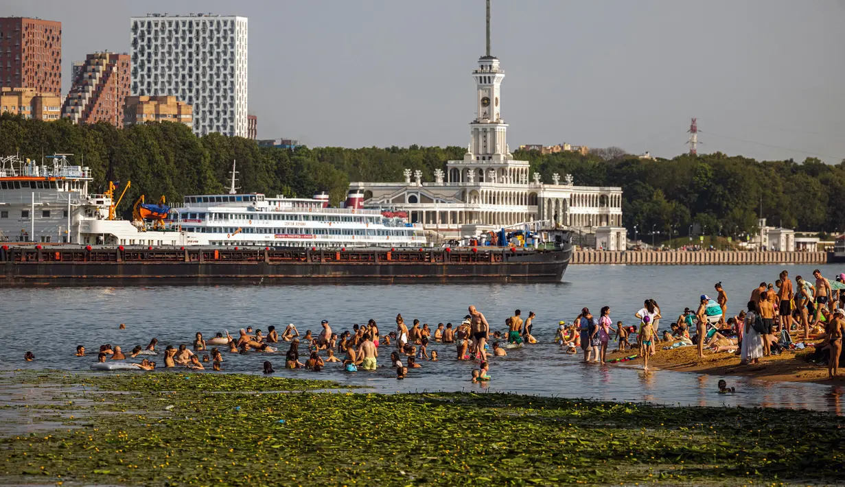 Orang-orang mendinginkan diri di Sungai Moskva pada musim panas di Moskow, Rusia, Selasa (13/7/2021). Layanan meteorologi Rusia mengatakan negara itu dapat melihat rekor musim panas terpanas, didorong oleh perubahan iklim, usai gelombang panas yang memecahkan rekor pada Juni. (DIMITAR DILKOFF/AFP)