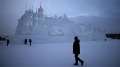 Sejumlah Pengunjung berjalan ditempat wahana es yang berda di kota utara Harbin, provinsi Heilongjiang , Cina, (5/1). Bangunan es yang dibuat menyerupai Istana dengan ukuran yang besar. (REUTERS/Aly Song)