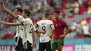 Penyerang Portugal, Cristiano Ronaldo berbicara dengan gelandang Jerman, Toni Kroos usai pertandigan grup F Euro 2020 di Allianz Arena, Munich, Sabtu (19/6/2021). Portugal takluk dari Jerman dengan skor 2-4. (AP Photo/Matthias Schrader, Pool)