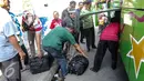 Sejumlah penumpang mengambil barang bawaannya saat turun dari bus di Terminal Pulo Gadung, Jakarta, Selasa (22/7/2015). Arus balik di Terminal Pulogadung hingga H+4 Lebaran mengalami peningkatan dibanding tahun lalu. (Liputan6.com/Faizal Fanani)