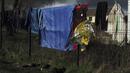 Barang-barang migran digantung di pagar di kamp darurat di luar Calais, Prancis utara, Sabtu (277/11/2021). Di kamp-kamp darurat di luar Calais, para migran yang putus asa menunggu kesempatan untuk mencoba menyeberangi Selat Inggris. (AP Photo/Rafael Yaghobzadeh)