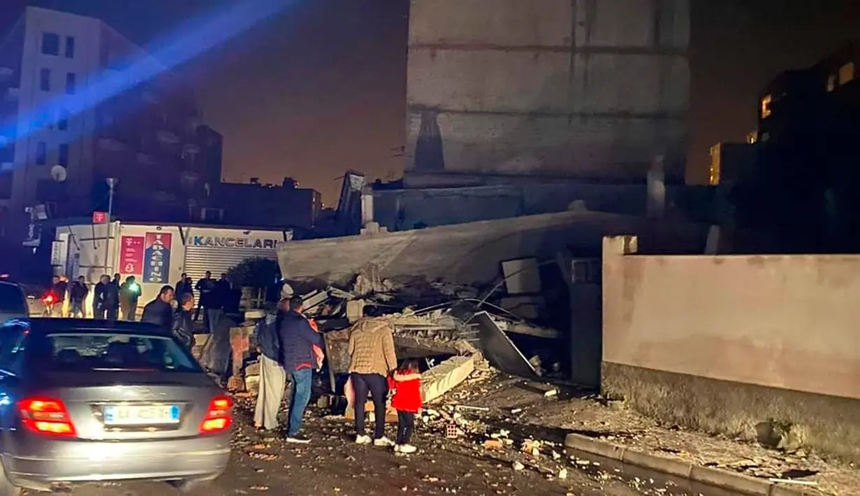 Orang-orang melihat kerusakan bangunan setelah gempa bumi di Durres,  Albania barat, Selasa (26/11/2019). Gempa bumi bermagnitudo 6,4 mengguncang Albania, Selasa dini hari yang menyebabkan beberapa bangunan dan gedung permukiman runtuh. (AP Photo)