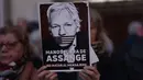 Seorang pengunjuk rasa memegang tanda bertuliskan "Hands off Assange, don't kill the messenger" dalam sebuah unjuk rasa untuk mendukung pendiri Wikileaks Julian Assange, di depan kedutaan besar Amerika Serikat (AS) di Madrid, pada tanggal 20 Februari 2024. (Thomas COEX/AFP)