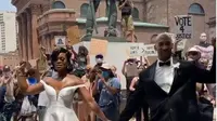 Pasangan pengantin berpose di tengah masa demonstran George Floyd. (dok. Instagram @luxorweddingfilms/ https://www.instagram.com/p/CBGs4OdnF1-/Dinny Mutiah)