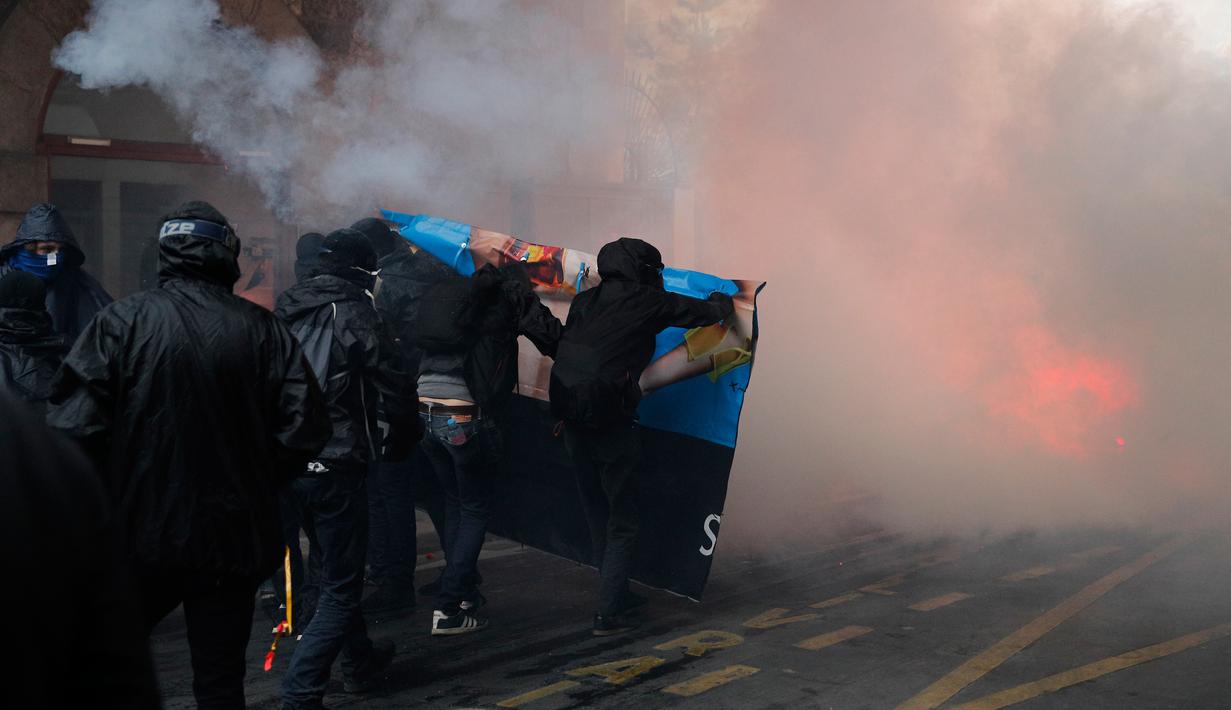Bentrokan terjadi antara massa aksi dan polisi anti huru-hara di Paris, Prancis (23/5). Mereka memprotes kebijakan pemerintah terkait pemangkasan 120.000 pekerjaan pada 2022. (AP/Christophe Ena)