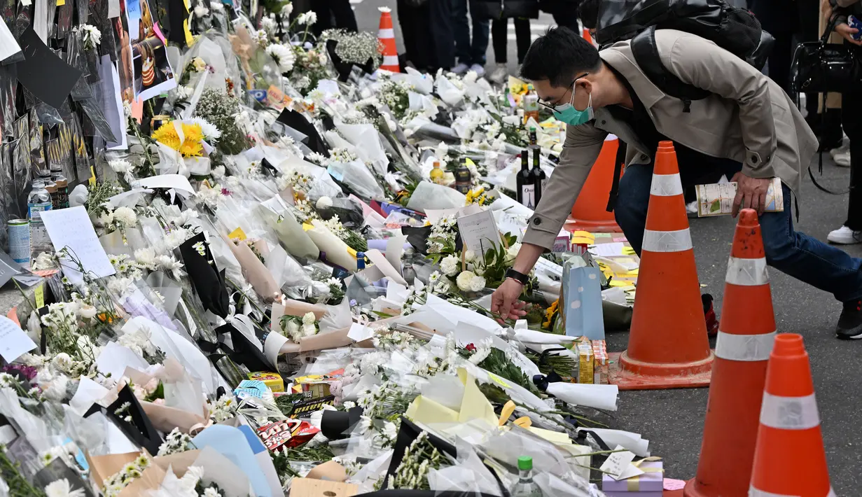Seorang pria meletakkan bunga di sebuah peringatan darurat untuk para korban akibat kerumunan massa dalam tragedi Halloween yang mematikan, di luar stasiun kereta bawah tanah di distrik Itaewon di Seoul, Kamis (3/11/2022). Bencana itu adalah yang paling mematikan di negara itu sejak tenggelamnya feri tahun 2014 yang menewaskan 304 orang, terutama siswa sekolah menengah. (Jung Yeon-je / AFP)