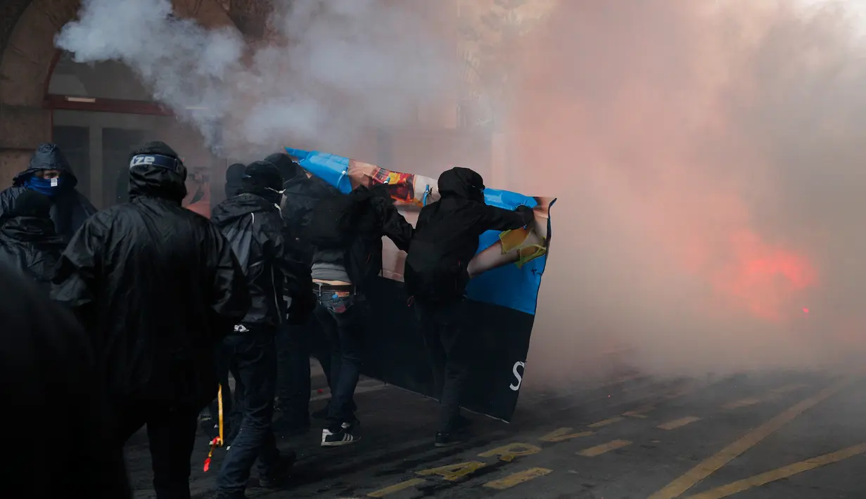 Bentrokan terjadi antara massa aksi dan polisi anti huru-hara di Paris, Prancis (23/5). Mereka memprotes kebijakan pemerintah terkait pemangkasan 120.000 pekerjaan pada 2022. (AP/Christophe Ena)