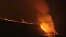 Pemandangan lava dari gunung berapi mencapai laut di pulau Canary La Palma, Spanyol, Rabu (29/9/2021) dinihari. Lava merah panas dari gunung berapi Cumbre Vieja mencapai Samudra Atlantik, sembilan hari setelah mulai mengalir menuruni gunung. (AP Photo/Daniel Roca)