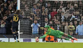 Penjaga gawang Manchester City Ederson, kanan, menyelamatkan penalti pemain Real Madrid Luka Modric saat adu penalti pada pertandingan sepak bola leg kedua perempat final Liga Champions antara Manchester City dan Real Madrid di Stadion Etihad di Manchester, Inggris, Rabu, 17 April 2024. ( Foto AP/Dave Shopland)