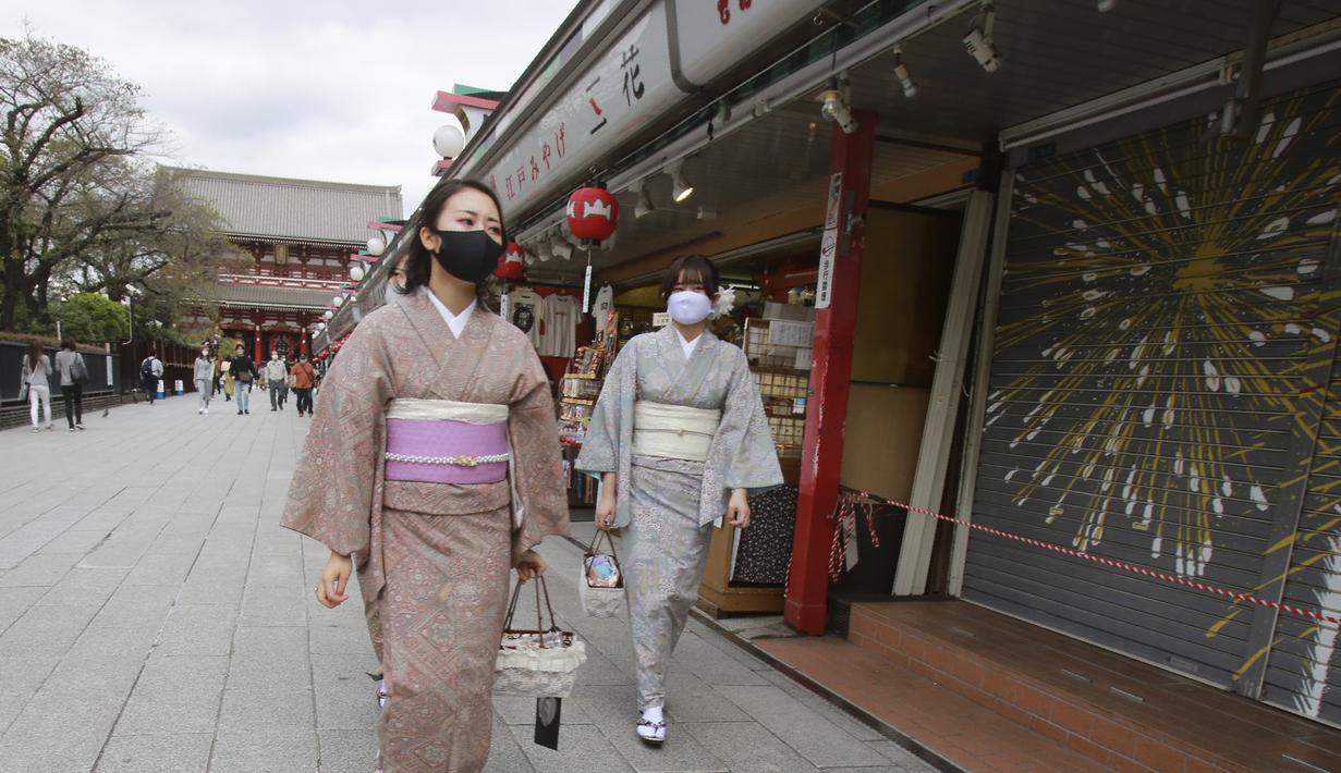 Pengunjung berpakaian kimono yang mengenakan masker untuk melindungi diri dari penyebaran virus corona berjalan-jalan di distrik Asakusa di Tokyo, Jepang, Rabu (14/10/2020). Tokyo mengonfirmasi lebih dari 170 kasus virus corona baru pada hari Rabu. (AP Photo/Koji Sasahara)