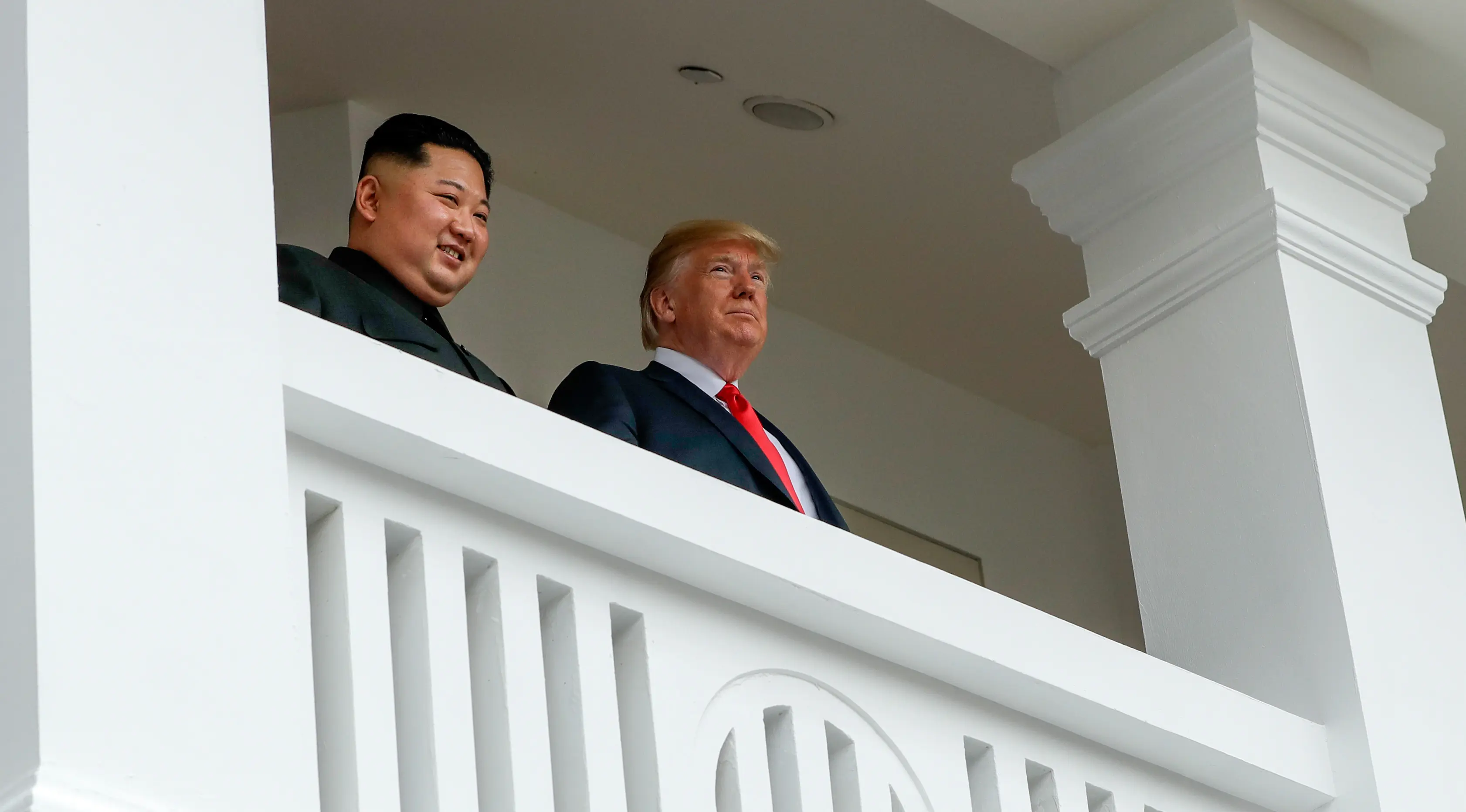 Pemimpin Korea Utara Kim Jong-un (kiri) dan Presiden AS Donald Trump melihat keluar dari balkon Hotel Capella di Pulau Sentosa, Singapura, Selasa (12/6). Sebelumnya, Trump dan Kim melakukan pembicaraan empat mata selama 35 menit. (AP Photo/Evan Vucci)