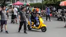 Pengendara sepeda motor listrik Migo saat melintasi CFD di kawasan Bundaran HI, Jakarta, Minggu (17/2). Petugas Dishub menghimbau penyewa untuk tidak melintasi jalan raya karena belum memenuhi uji layak operasi. (Liputan6.com/Faizal Fanani)